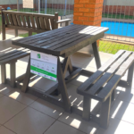 Picnic table made from recycled plastic on a patio next to a pool